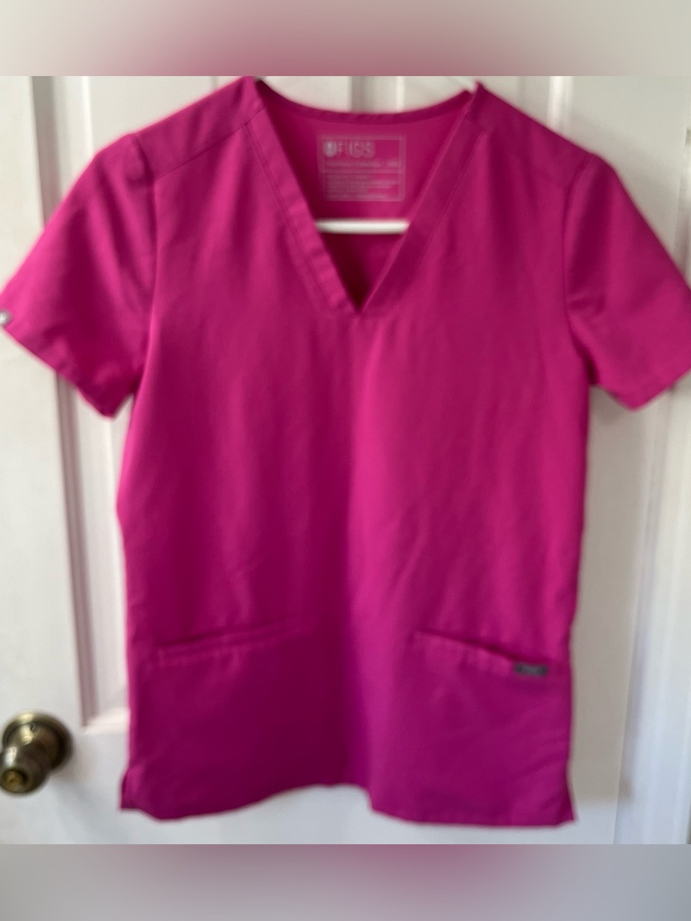 FIGS Casma Three-Pocket Scrub Top in a vibrant, limited-edition bright fuchsia